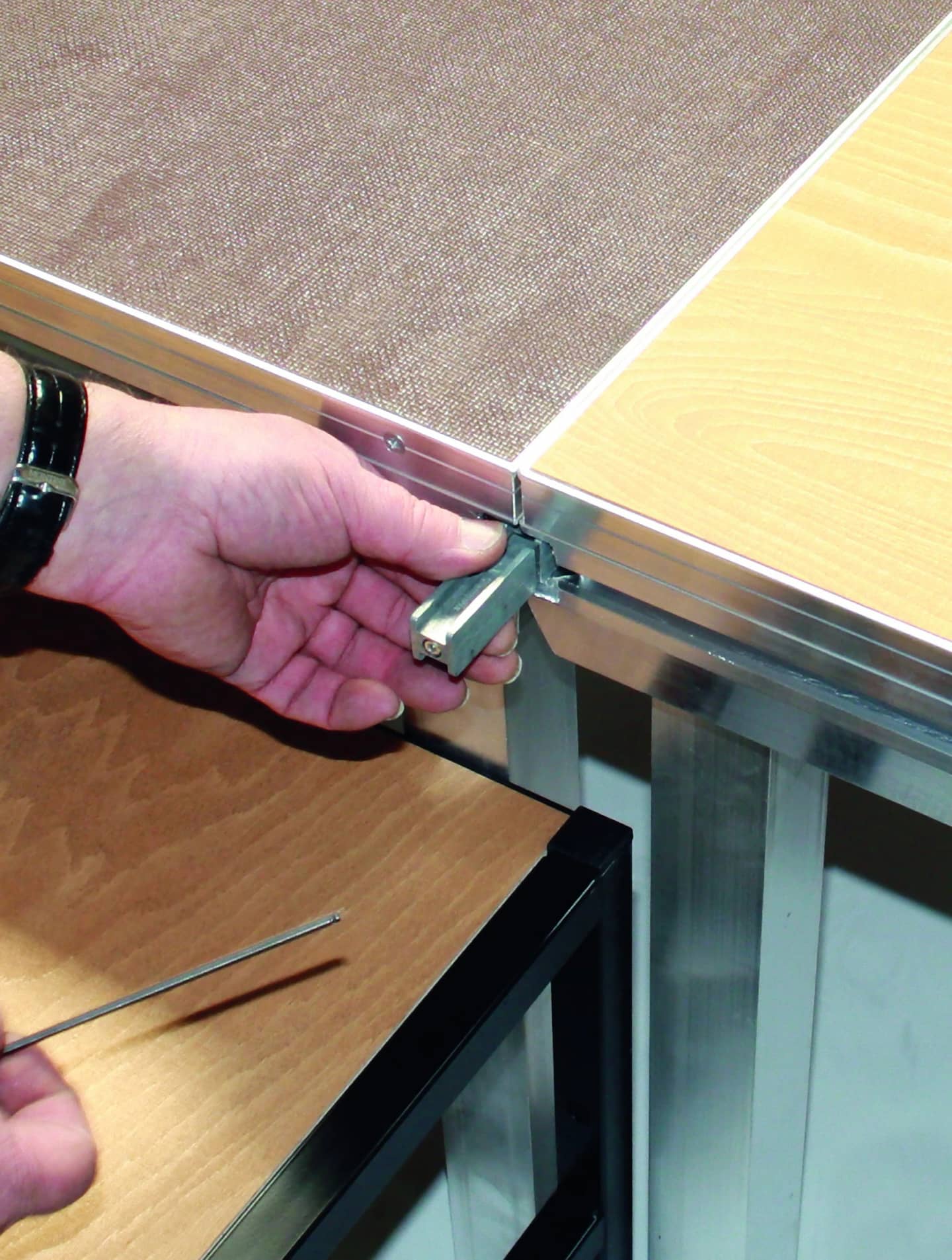 Hand zieht das Handrad an der Beinbefestigungsecke eines BÜTEC Steckbeinpodests an