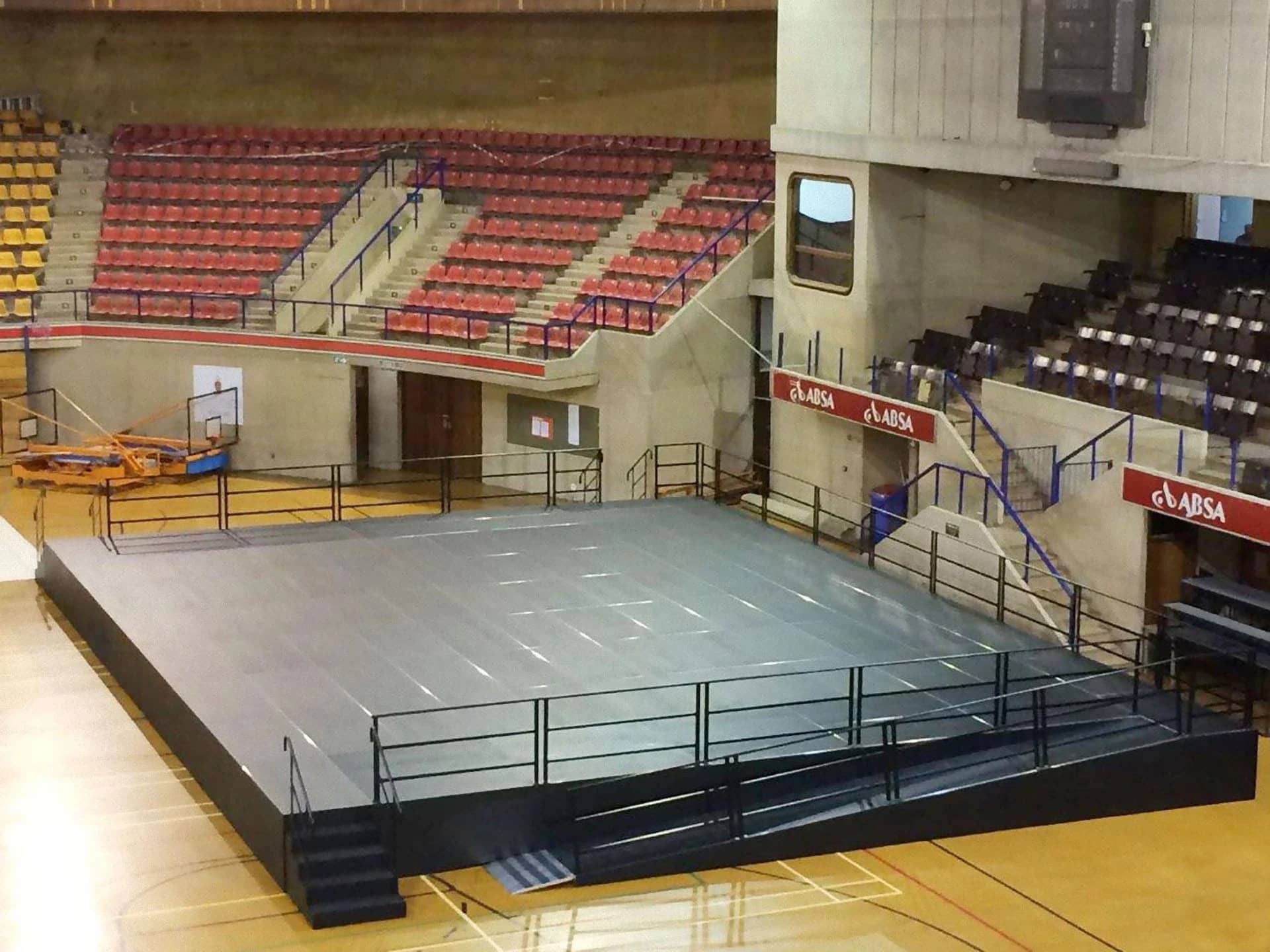 Bühne aus BÜTEC Steckbeinpodesten mit Geländer, Treppe und Rampe in einer Sporthalle