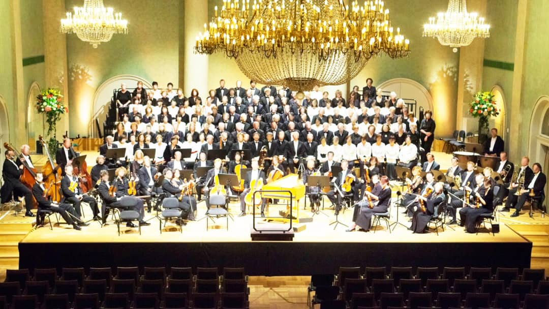 Orchestra and choir on a stepped BÜTEC stage in a concert hall