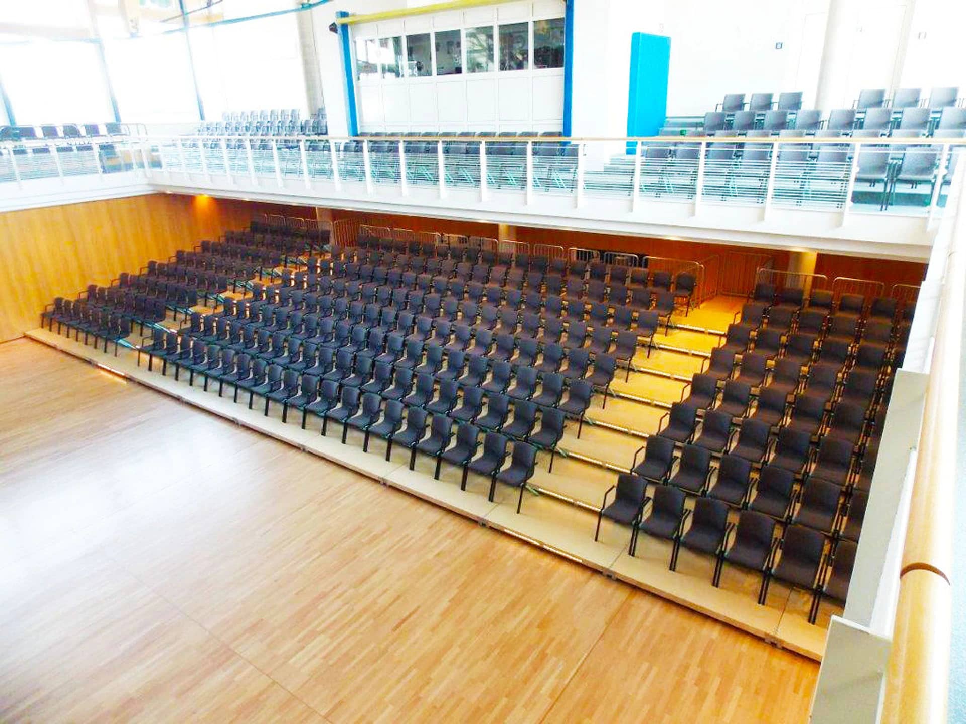 Ausgezogene BÜTEC Push'n Pull Teleskoptribüne mit Bestuhlung in einer Sporthalle
